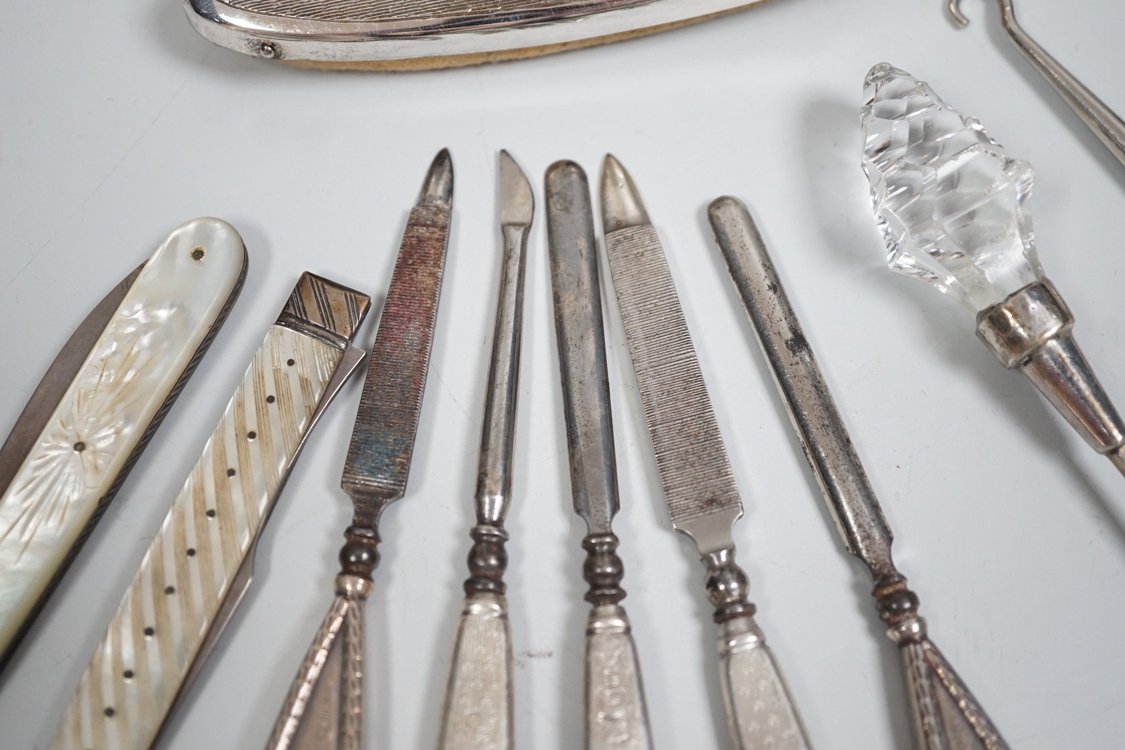 A small group of assorted manicure items and a leather travelling case containing a matched silver and mother of pearl travelling knife and fork.